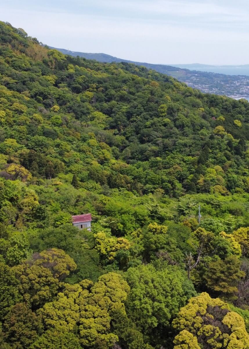 Drone shot of an akiya on a mountain overlooking the ocean in Atami, Shizuoka, Japan.