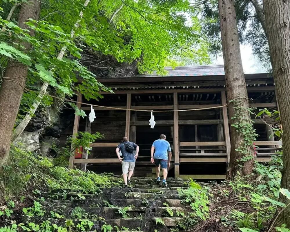 akiyaz-nagano-templeStairs-4x5-1000-tiny Akiyaz CEO Matt Ketchum hiking up a mountain towards a temple with a client in Nagano, Japan.